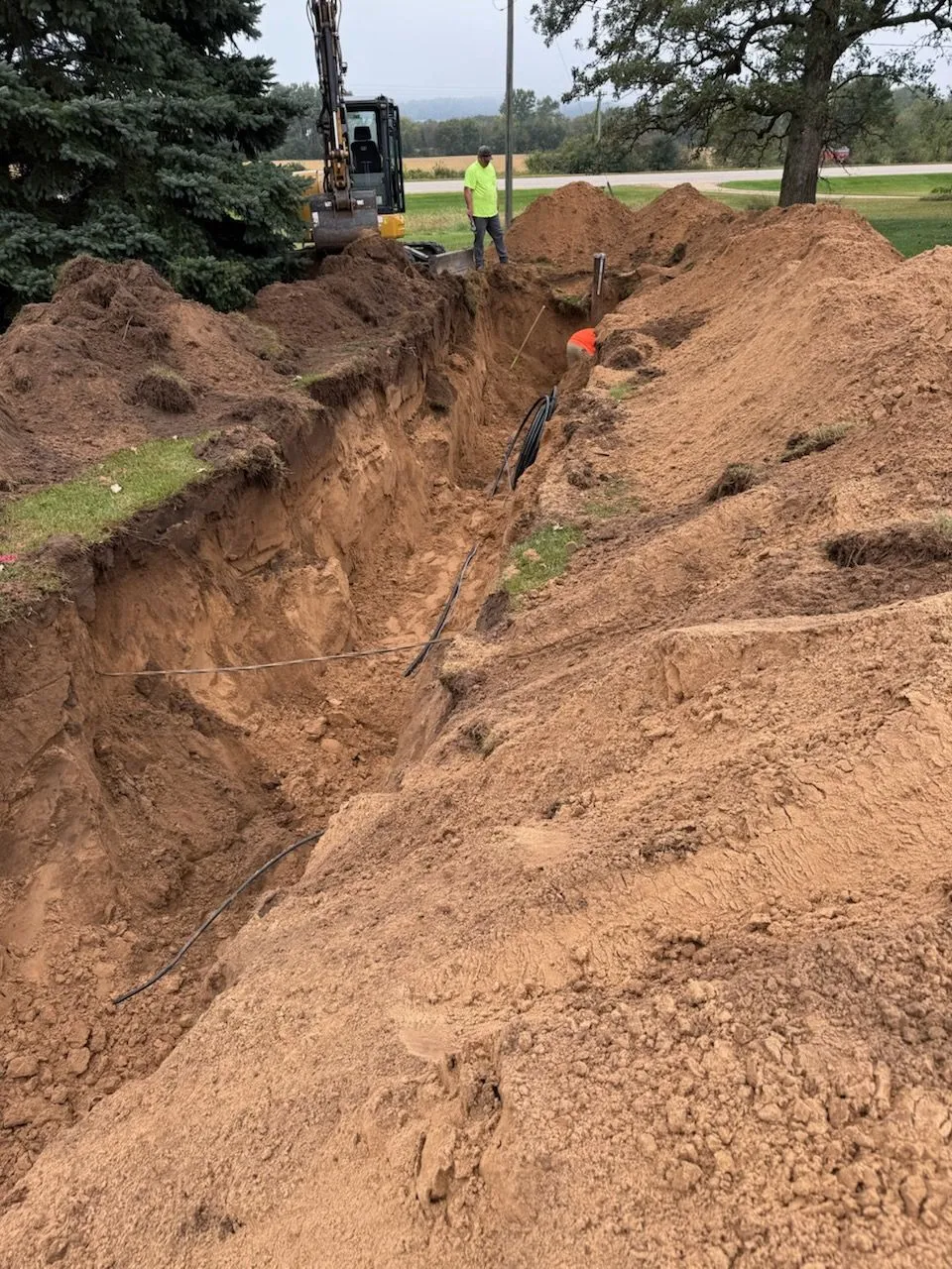 Excavator trenching for utility line install